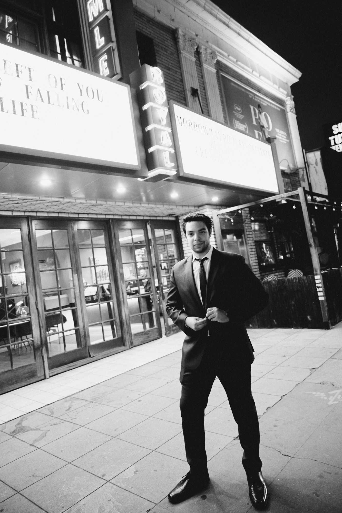 Jake Peress standing outside the Royal Theatre marquee at night, Los Angeles